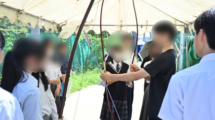 弓道部、弓の持ち方について説明する生徒