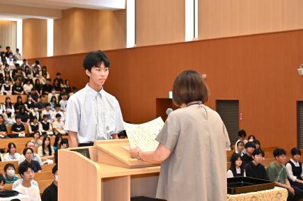 全校集会で校長より表彰される藤田さん（2年）