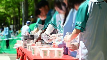 大量の紙コップに水・ドリンクを用意し選手を待つ