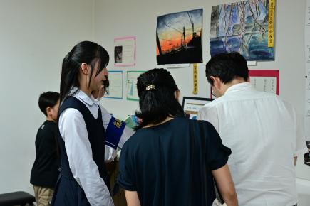 在校生の教材、ノート等を熱心に眺める参加者